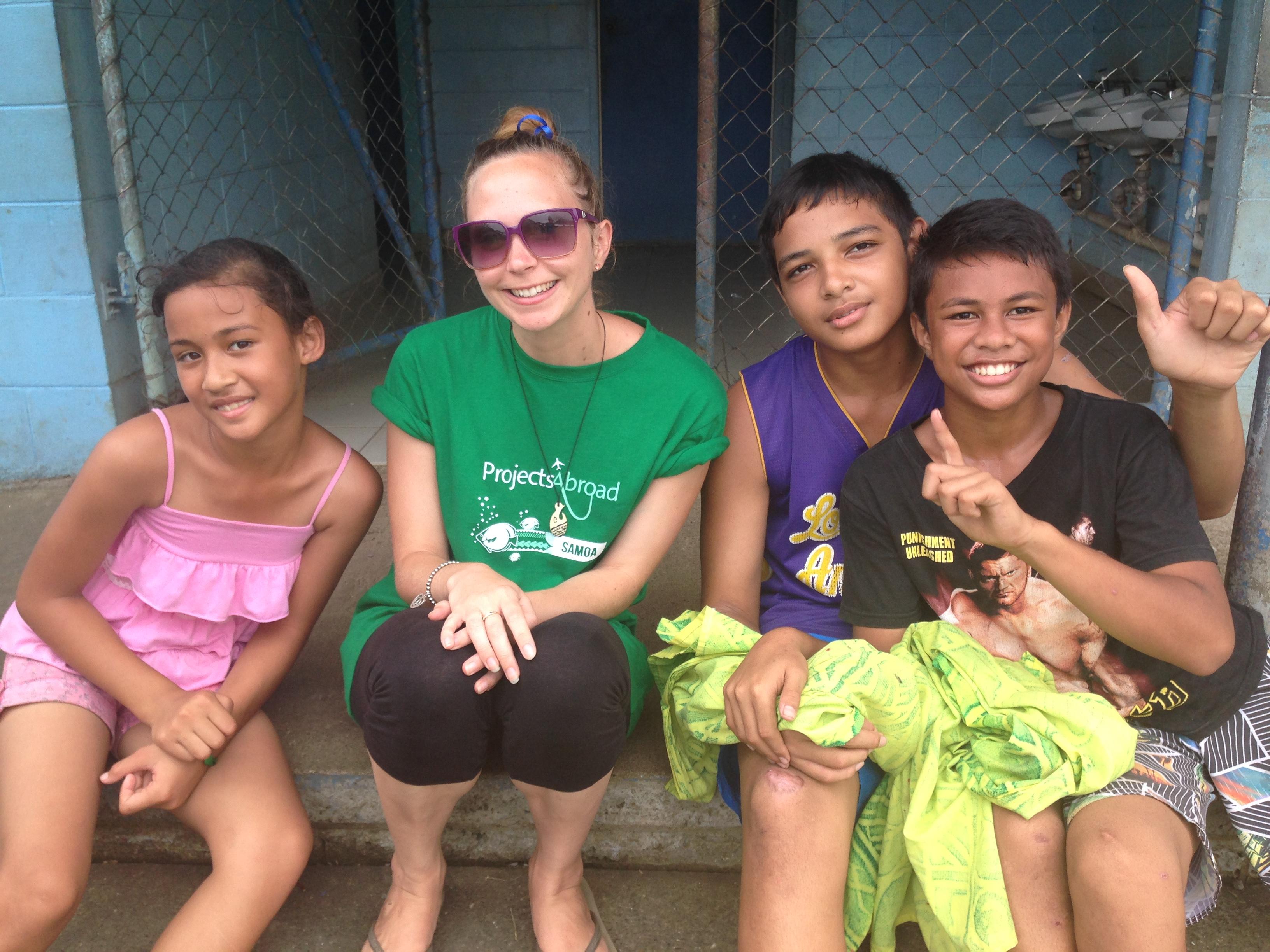 A Projects Abroad Childcare volunteer in Samoa takes a picture with children at her placement A Childcare volunteer in Samoa poses for a picture with children at her placement